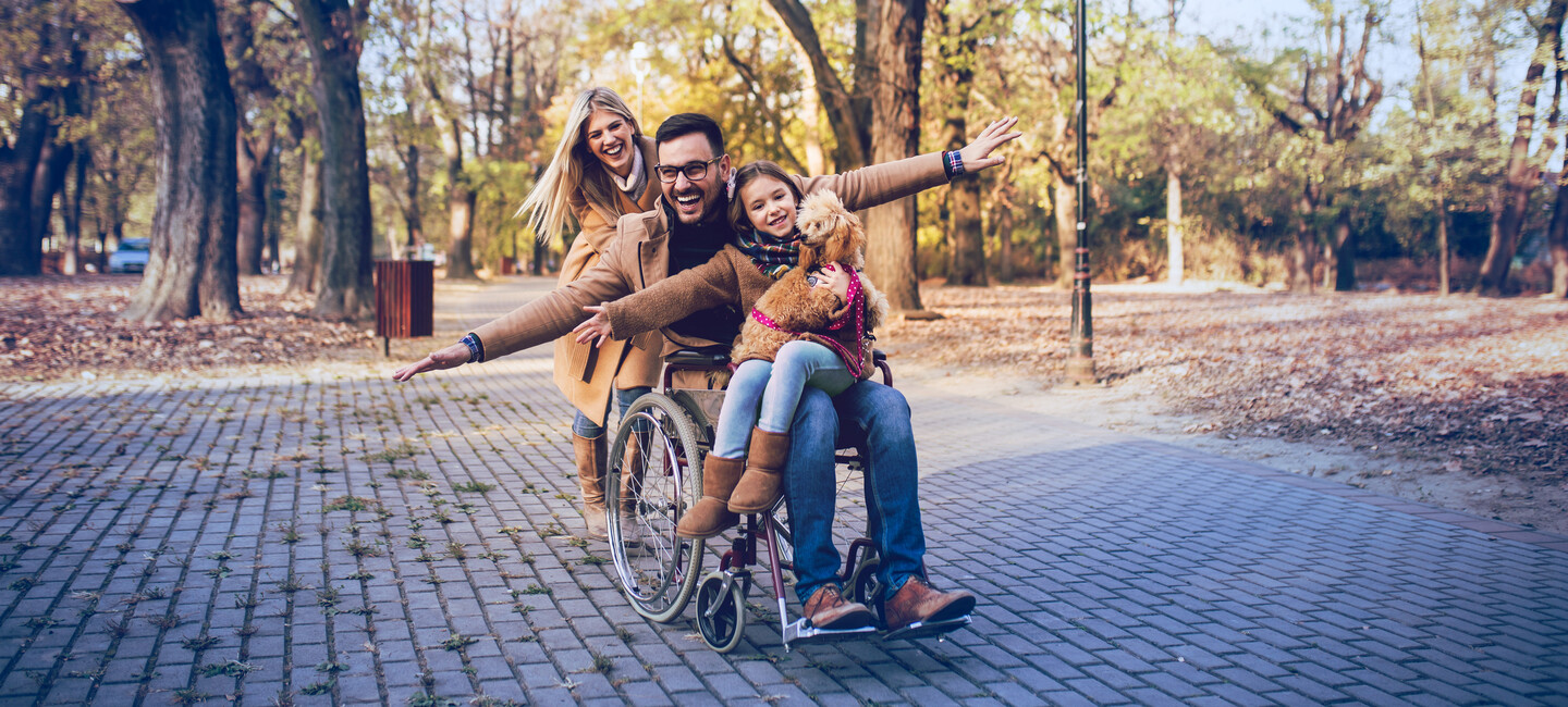 Mann im Rollstuhl mit seiner Familie