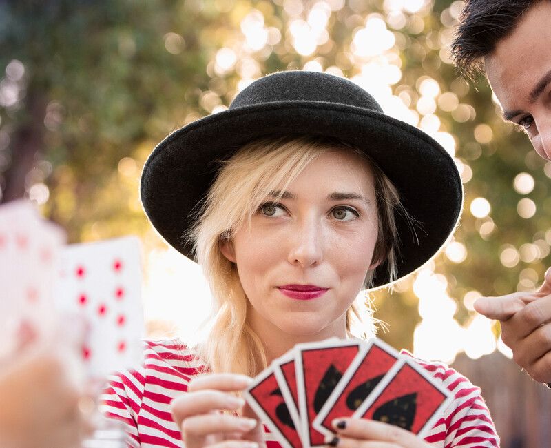 Frau spielt Kart und Mann schaut lachend in die Karten