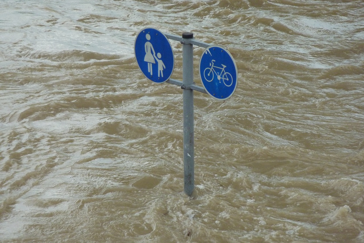Straßenschild geht unter in Wasserflut