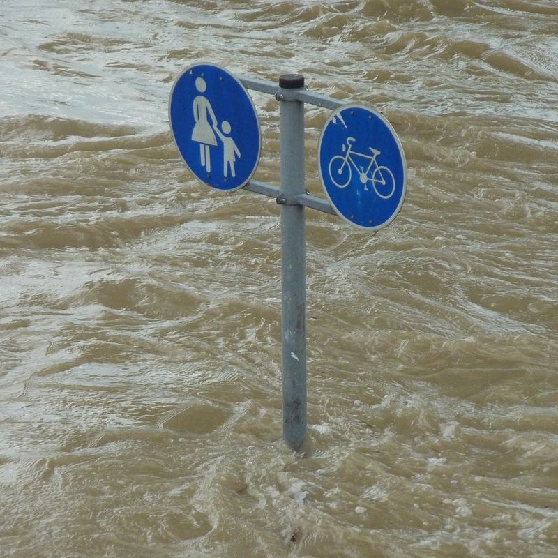 Straßenschild geht unter in Wasserflut