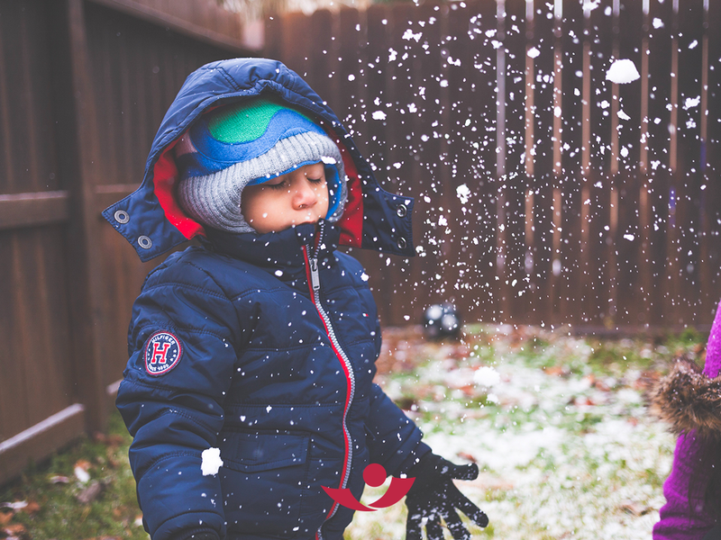 Kind wirft Schnee hoch