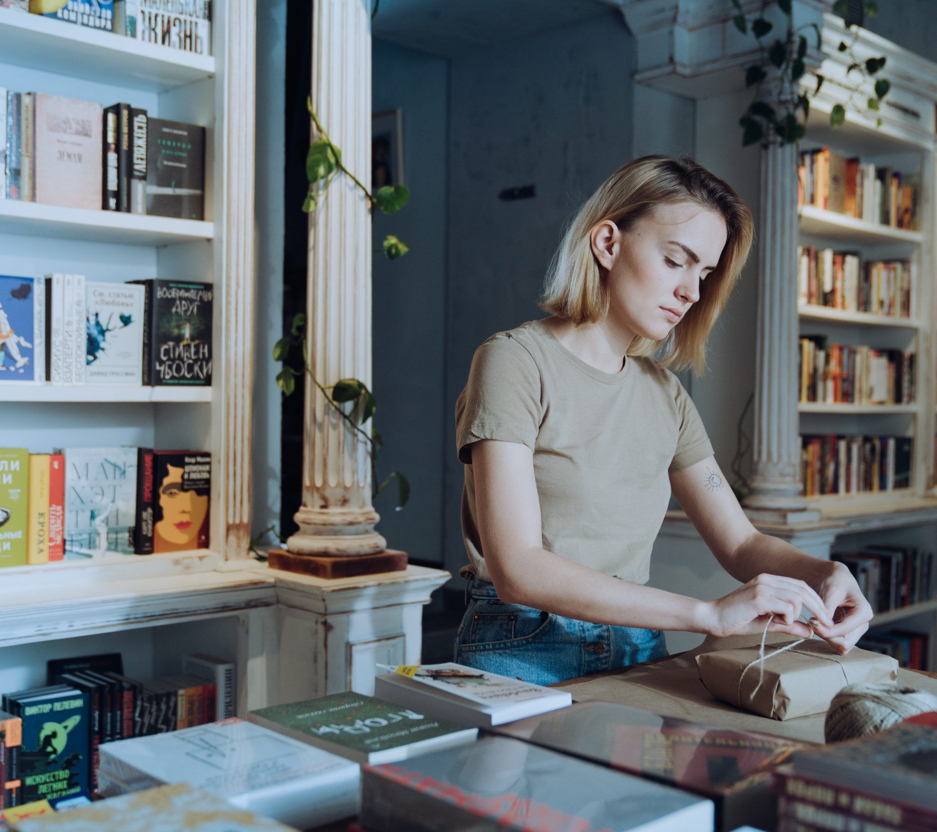 Frau im Buchladen verpackt Geschenk
