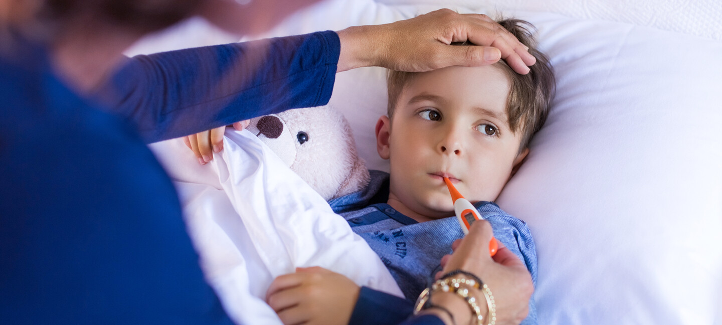 Kind mit Fieberthermometer im Mund
