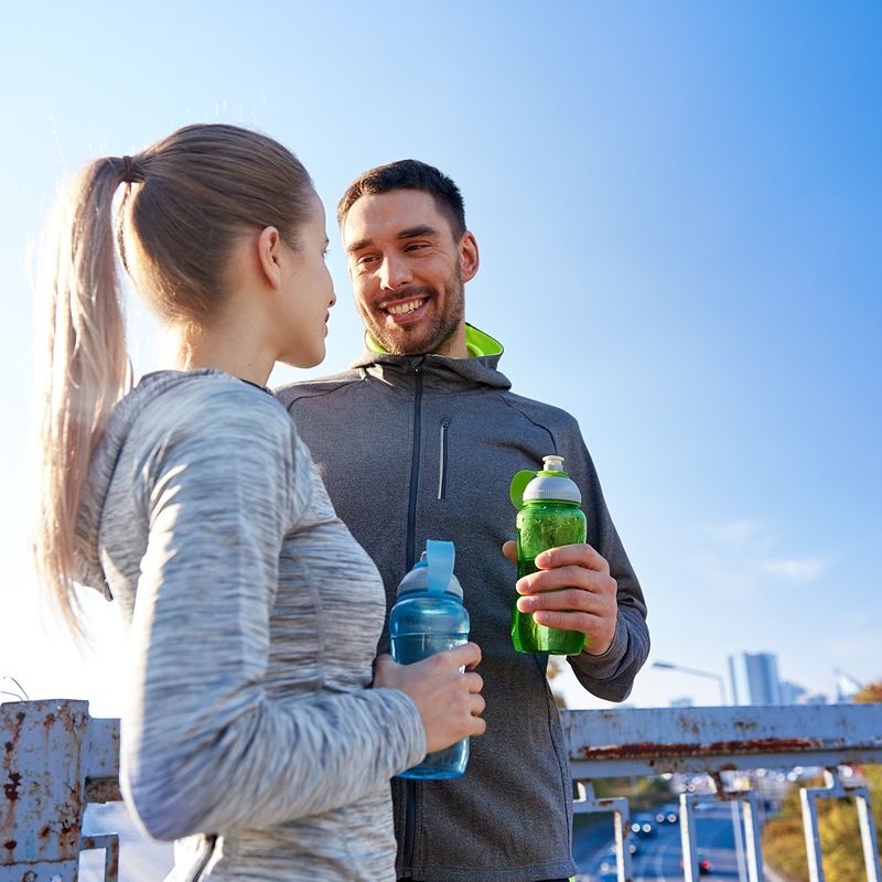 Frau und Mann trinken Wasser beim Sport