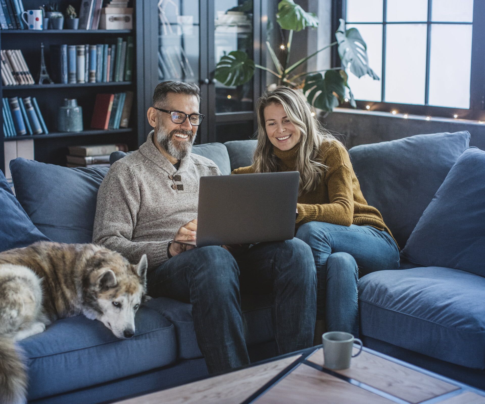 Paar mit Laptop auf Couch