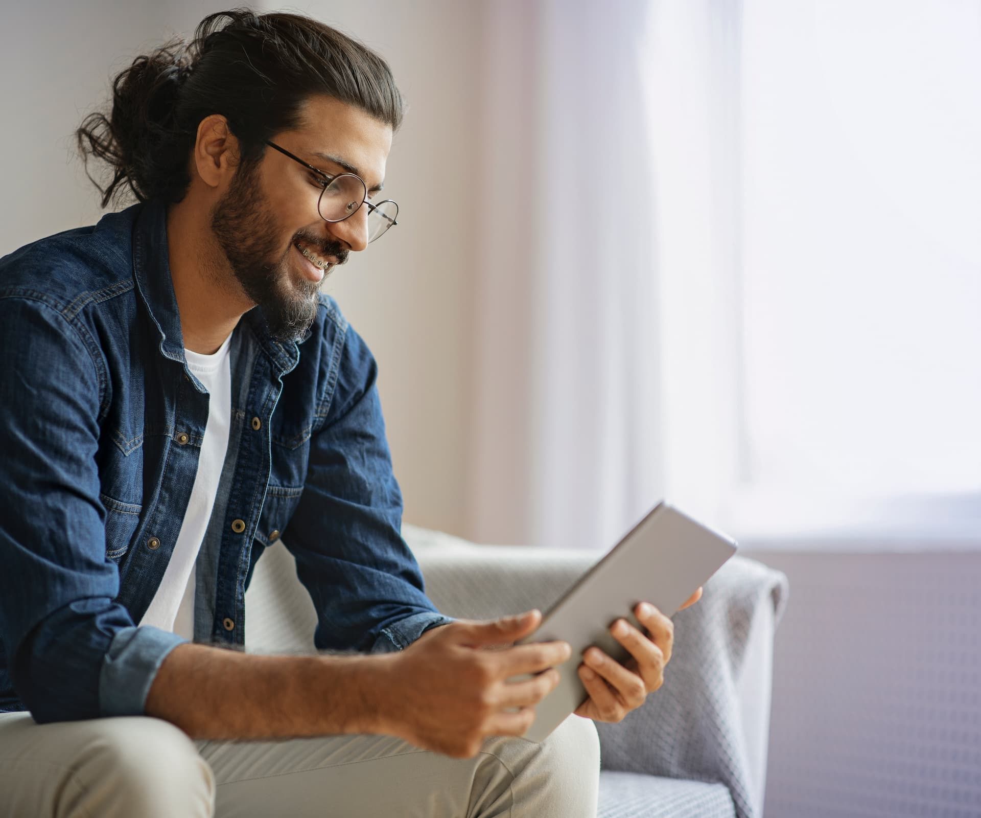 Junger Mann liest auf Tablet