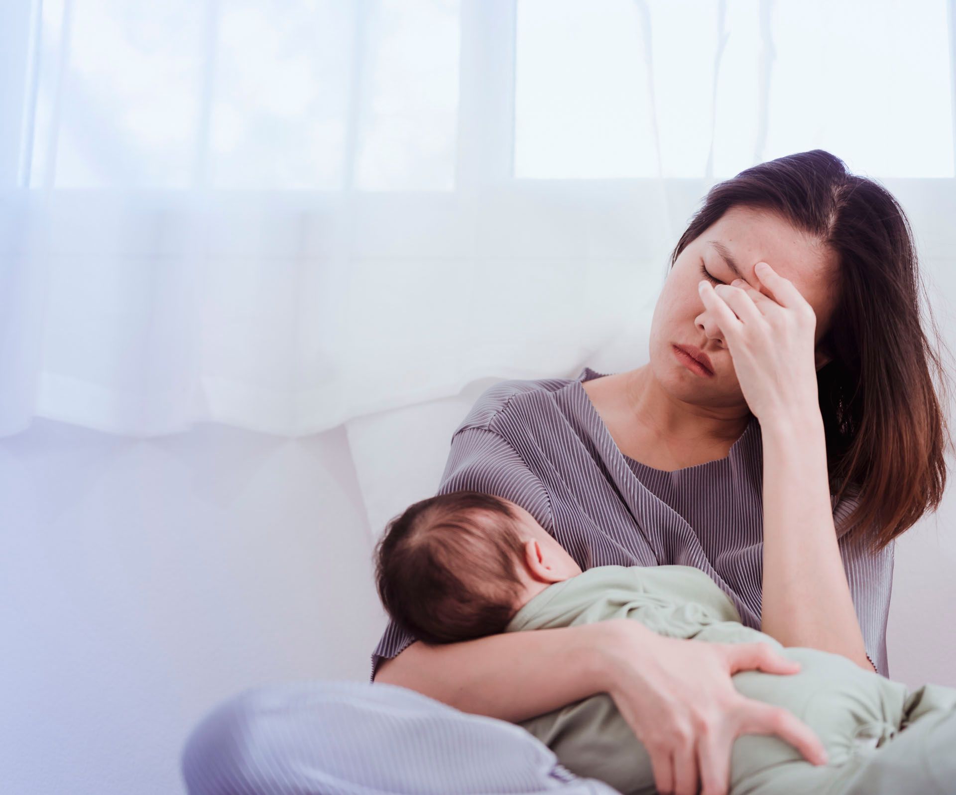 Erschöpfte Mutter mit Baby