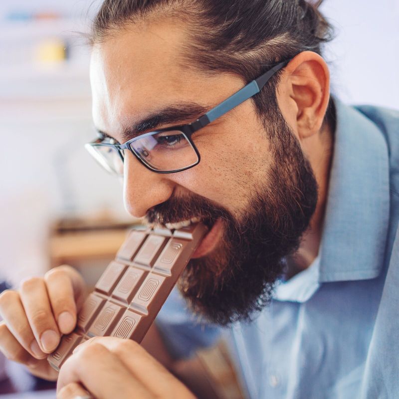 Mann isst Tafel Schokolade