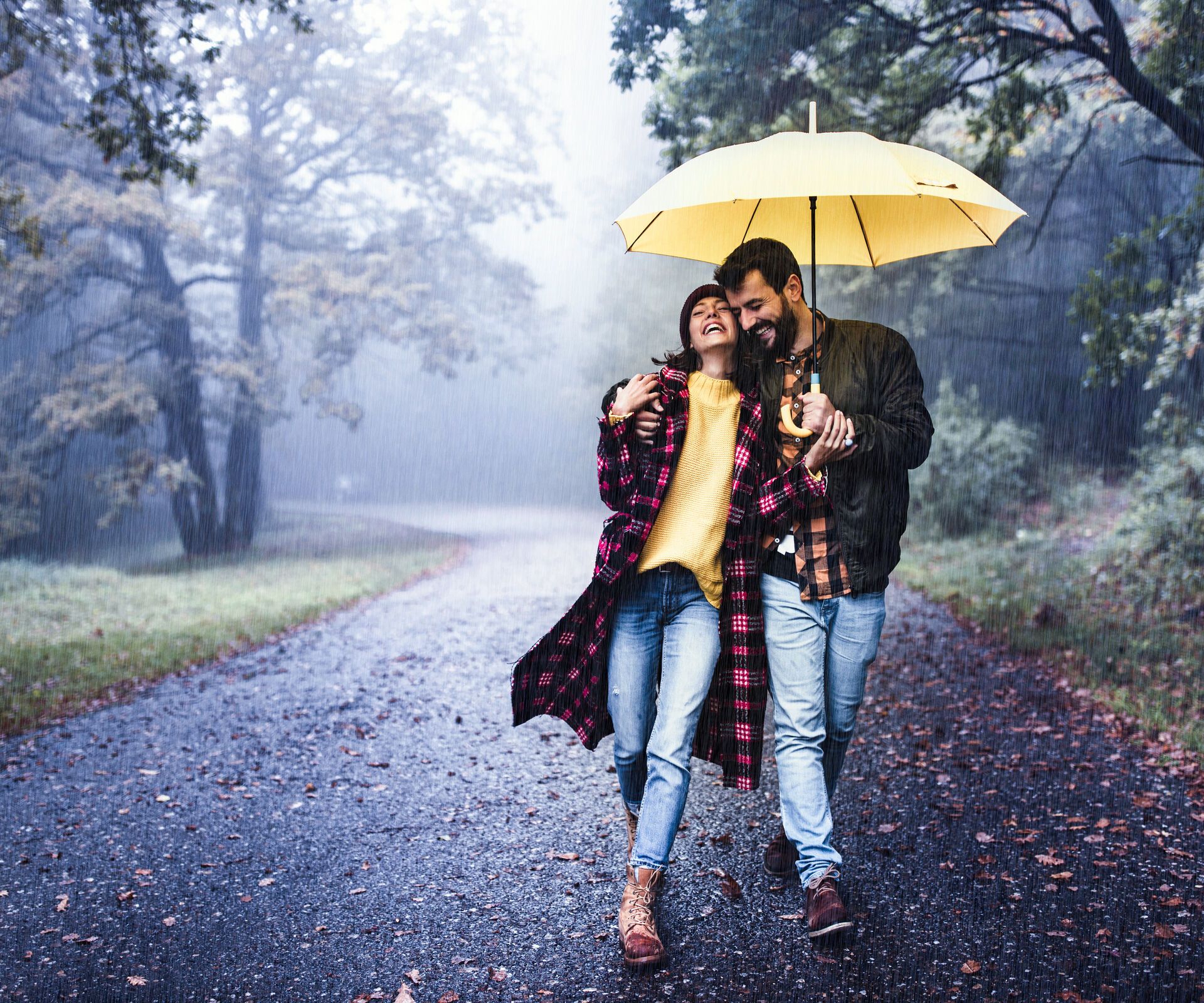 Paar spaziert gut gelaunt im Regen