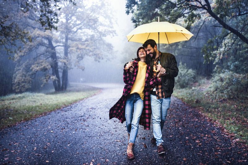 Paar spaziert gut gelaunt im Regen