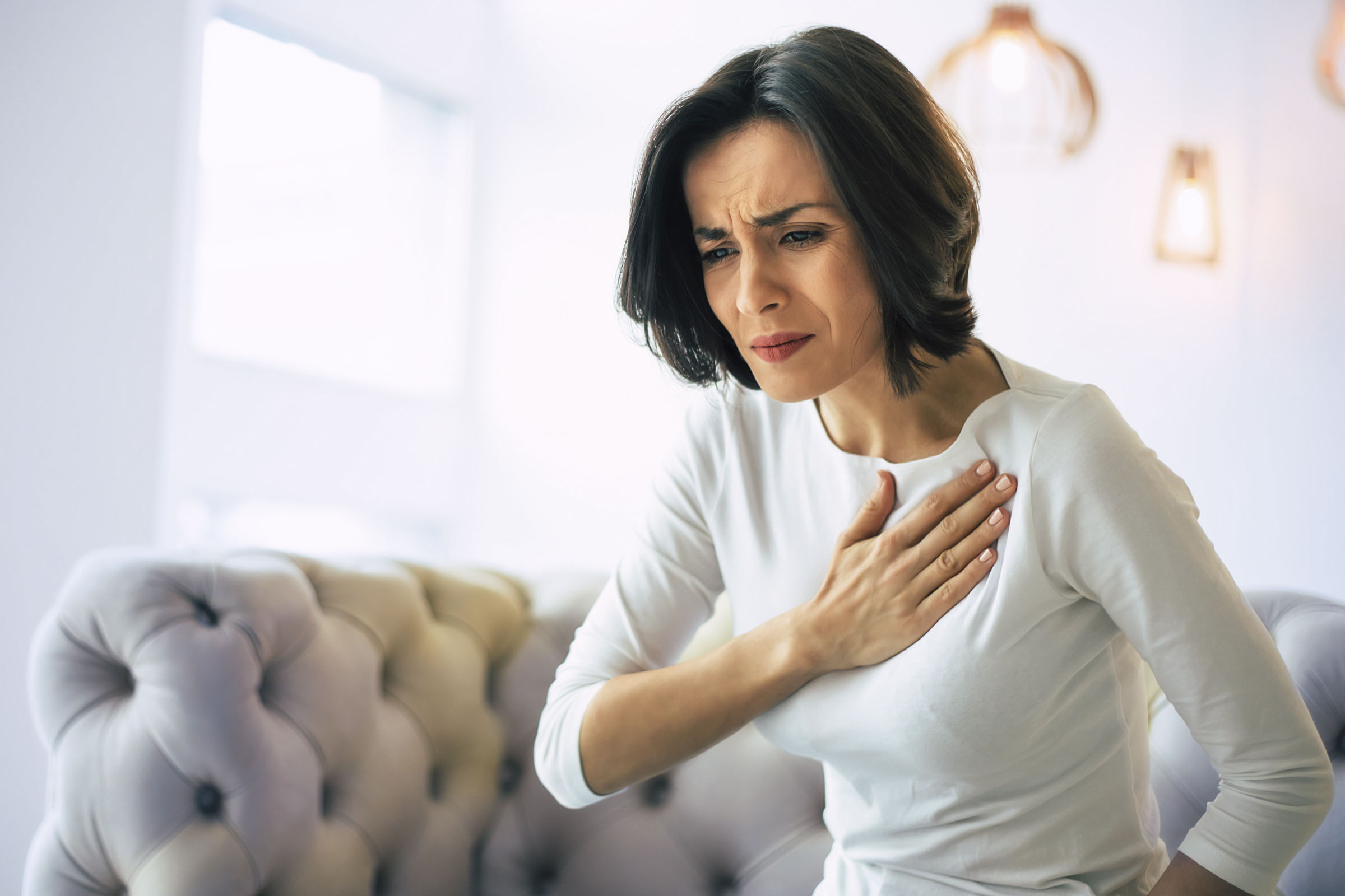 Herzinfarkt - Frau verspürt Schmerz in Brustbereich