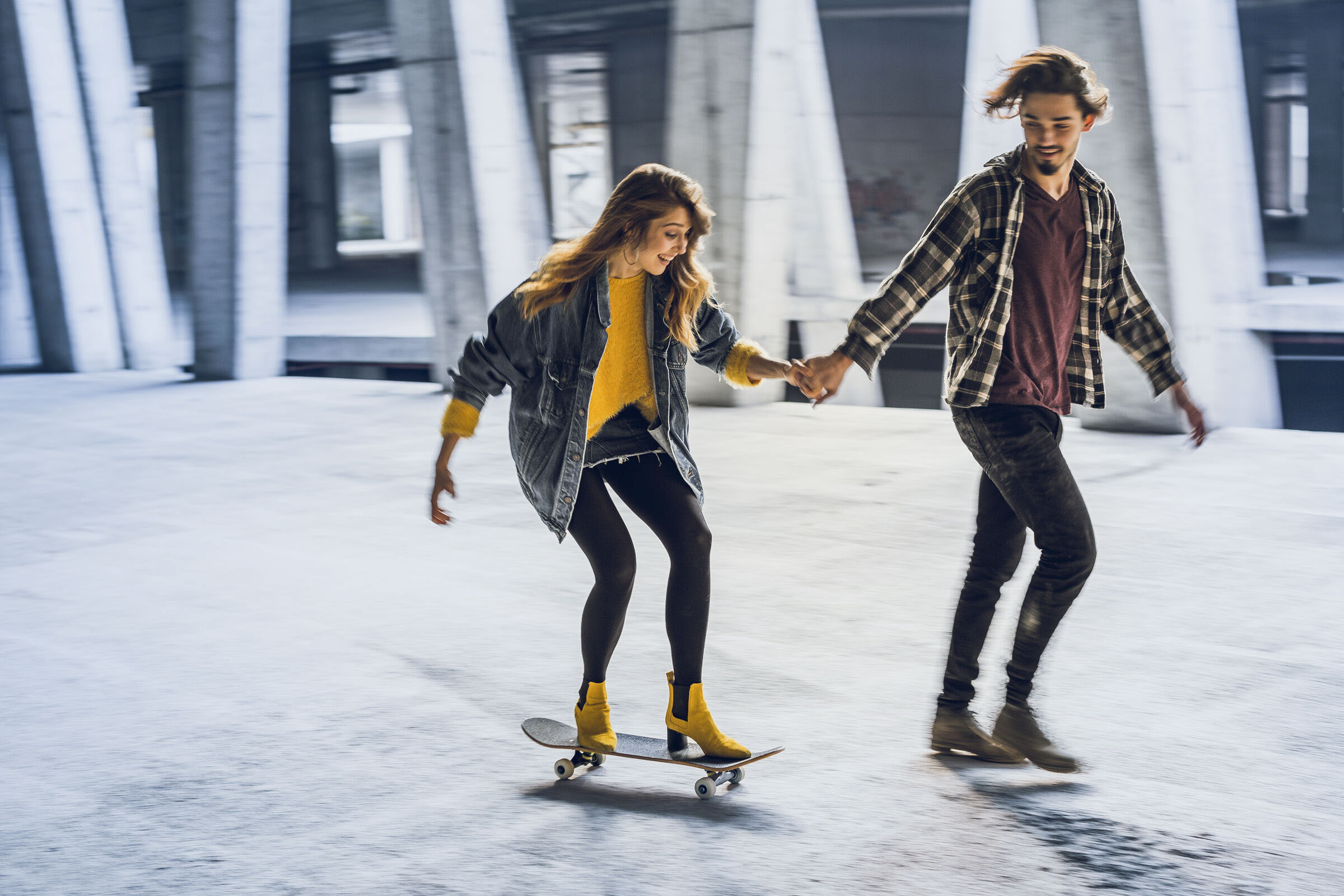Paar in Stadt fährt Skateboard