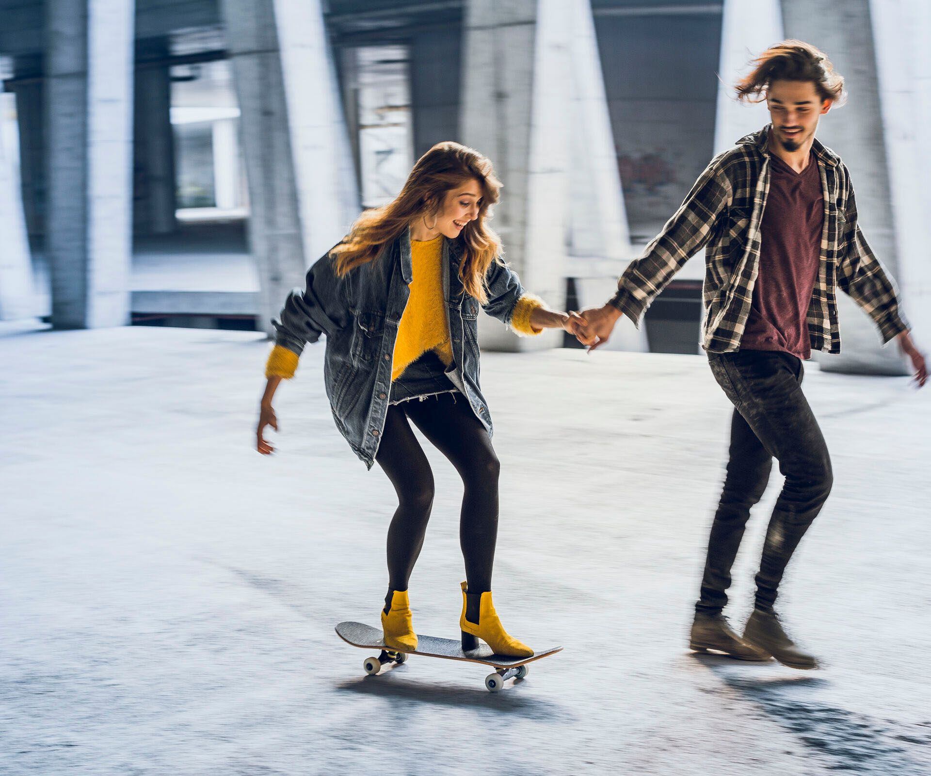 Paar in Stadt fährt Skateboard