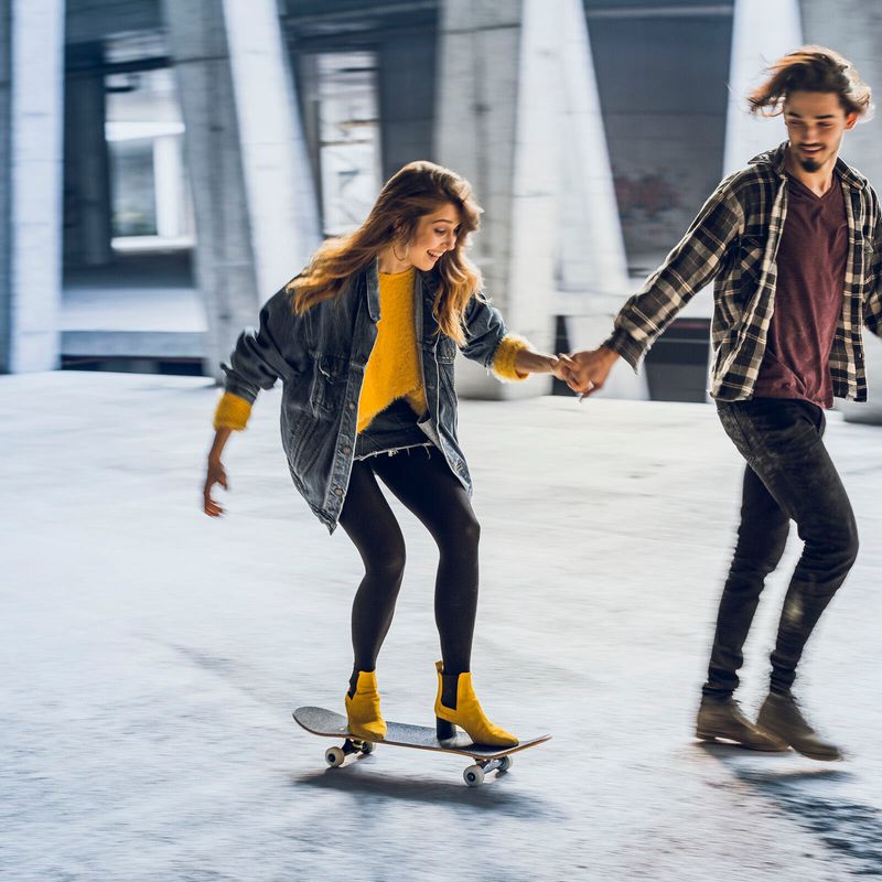 Paar in Stadt fährt Skateboard