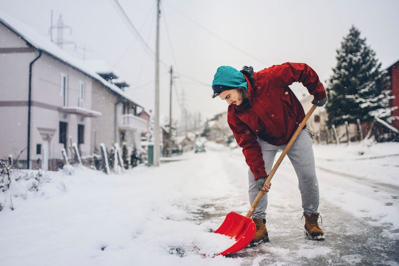 Mann schippt Schnee