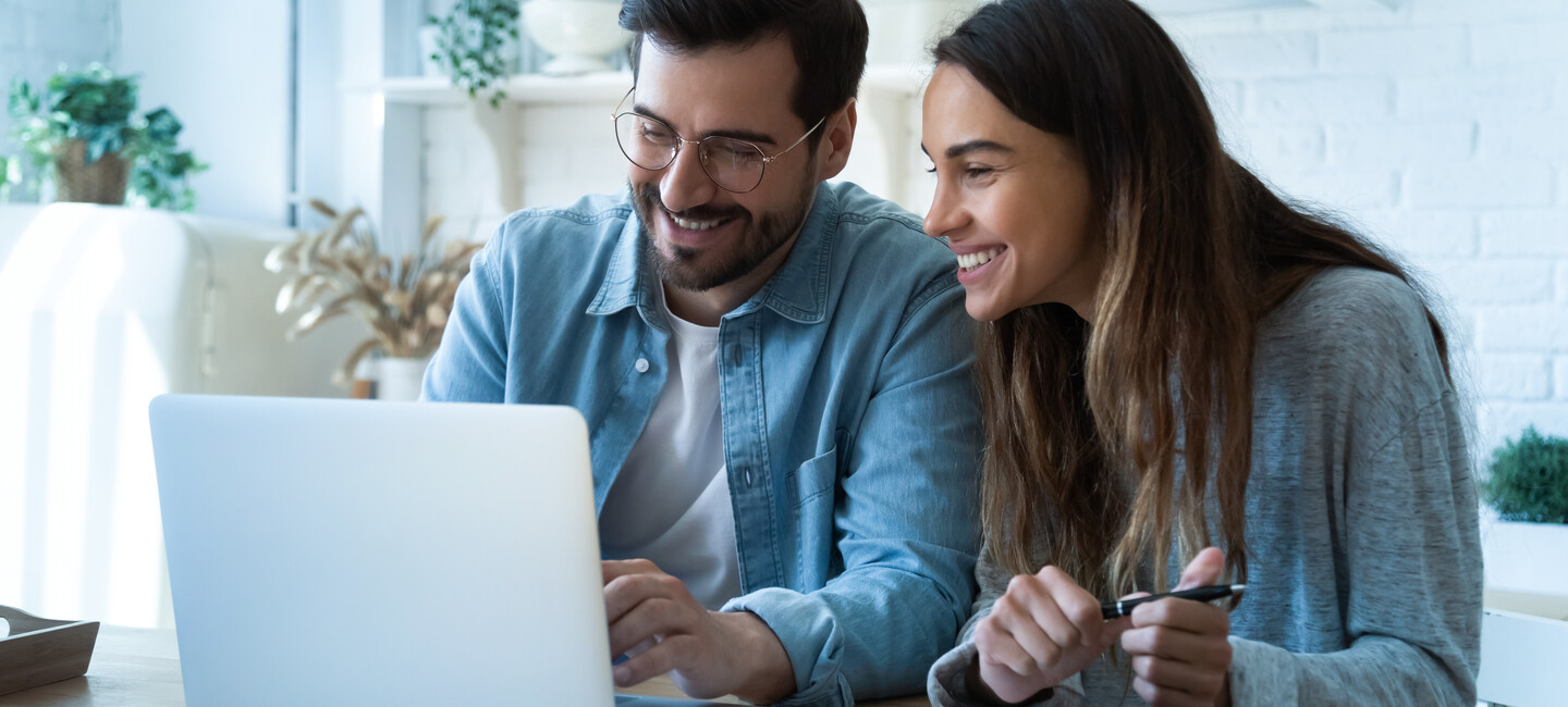 Mann und Frau sitzen vorm Laptop