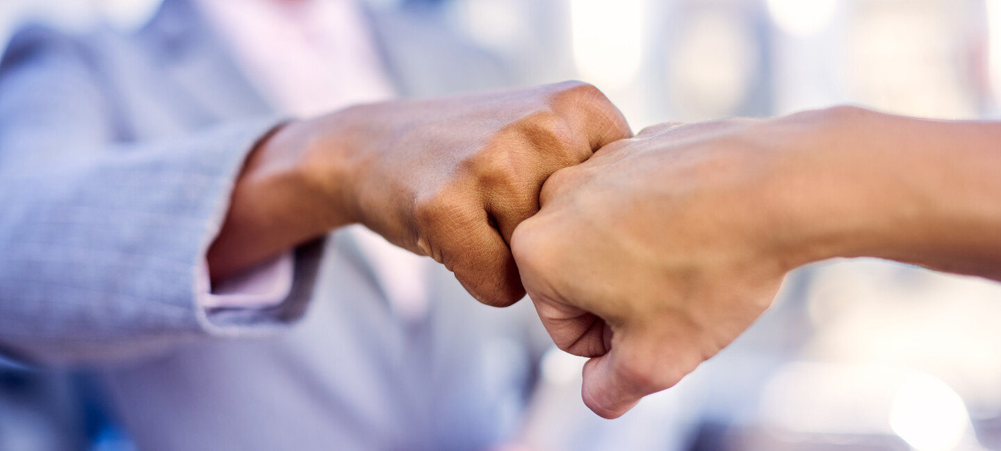 Frau grüßt mit Handschlag