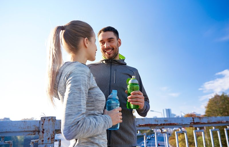 Frau und Mann trinken Wasser beim Sport