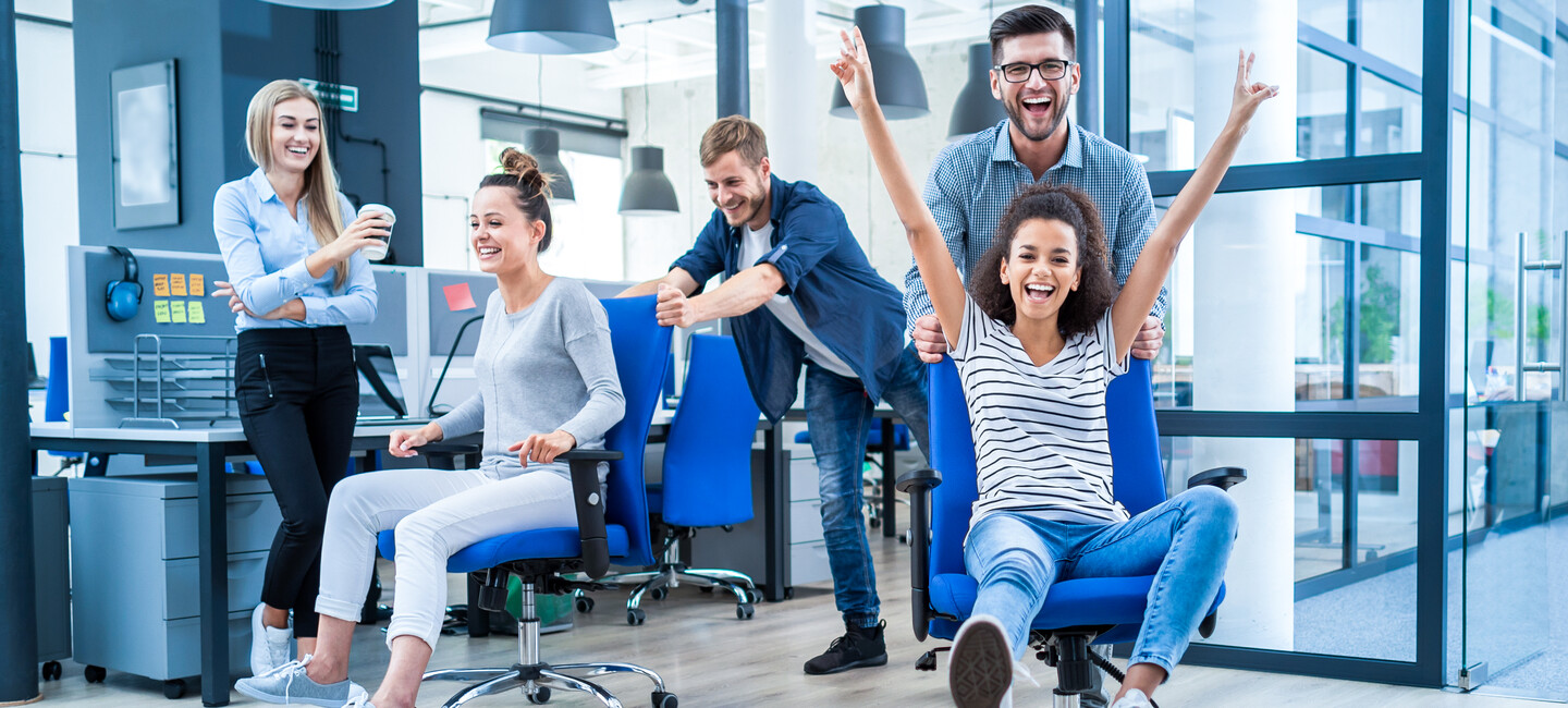 Junges dynamisches glückliches Team hat Spaß im Büro