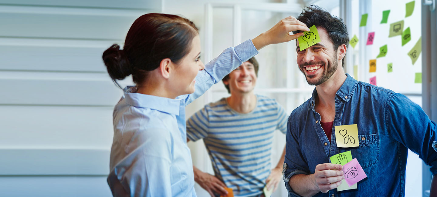 Frau klebt Mann einen Post-It an den Kopf