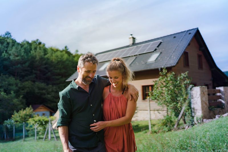 Paar vor Haus mit Solaranlage