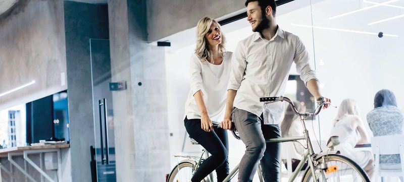 Mann und Frau auf Tandem im Büro