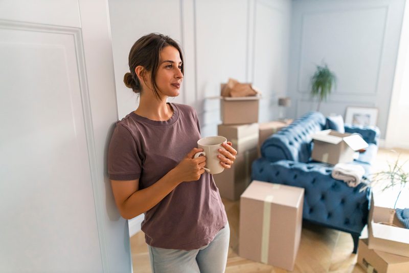 Frau macht Kaffeepause beim Umzug