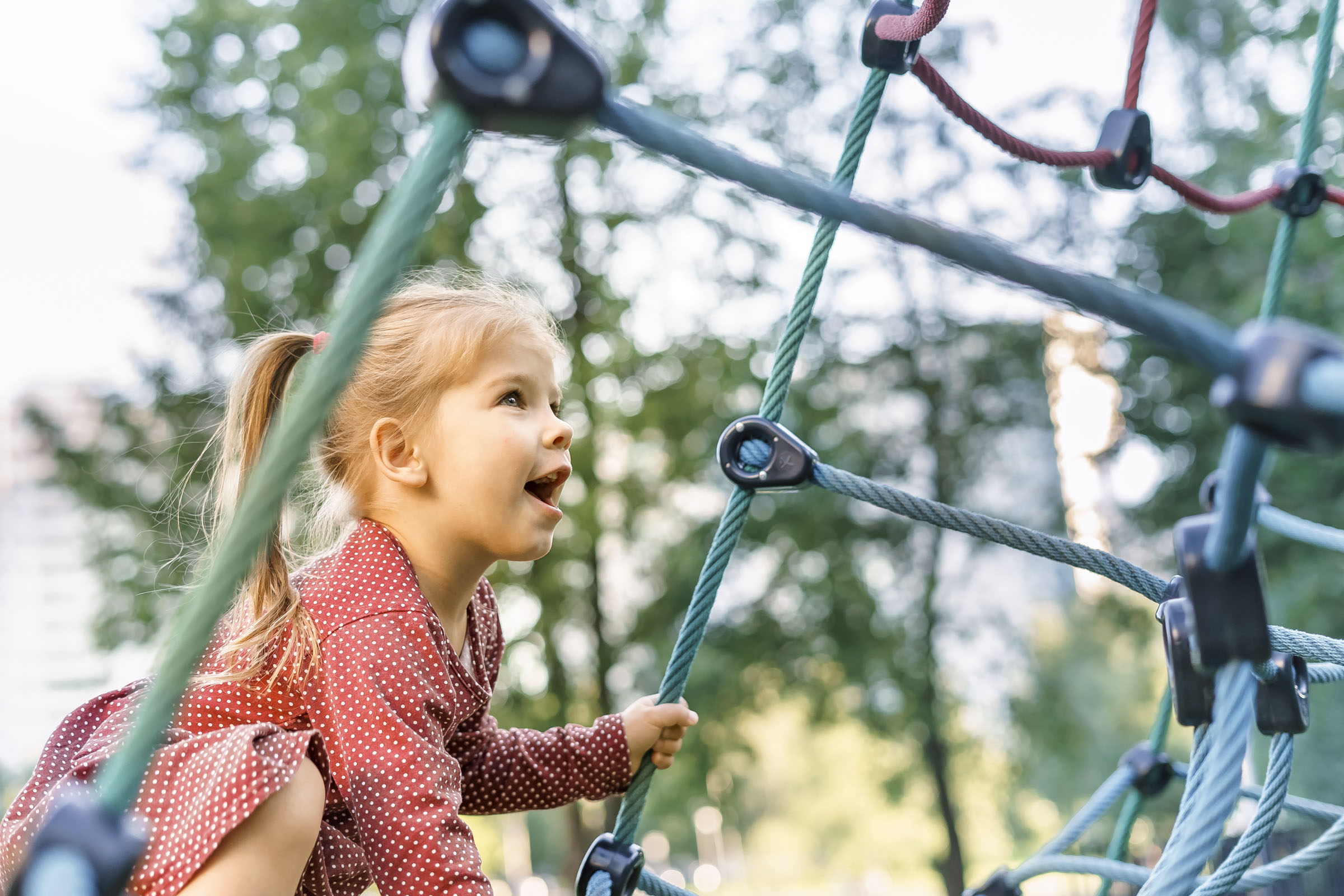 Mädchen klettert auf Spielplatz