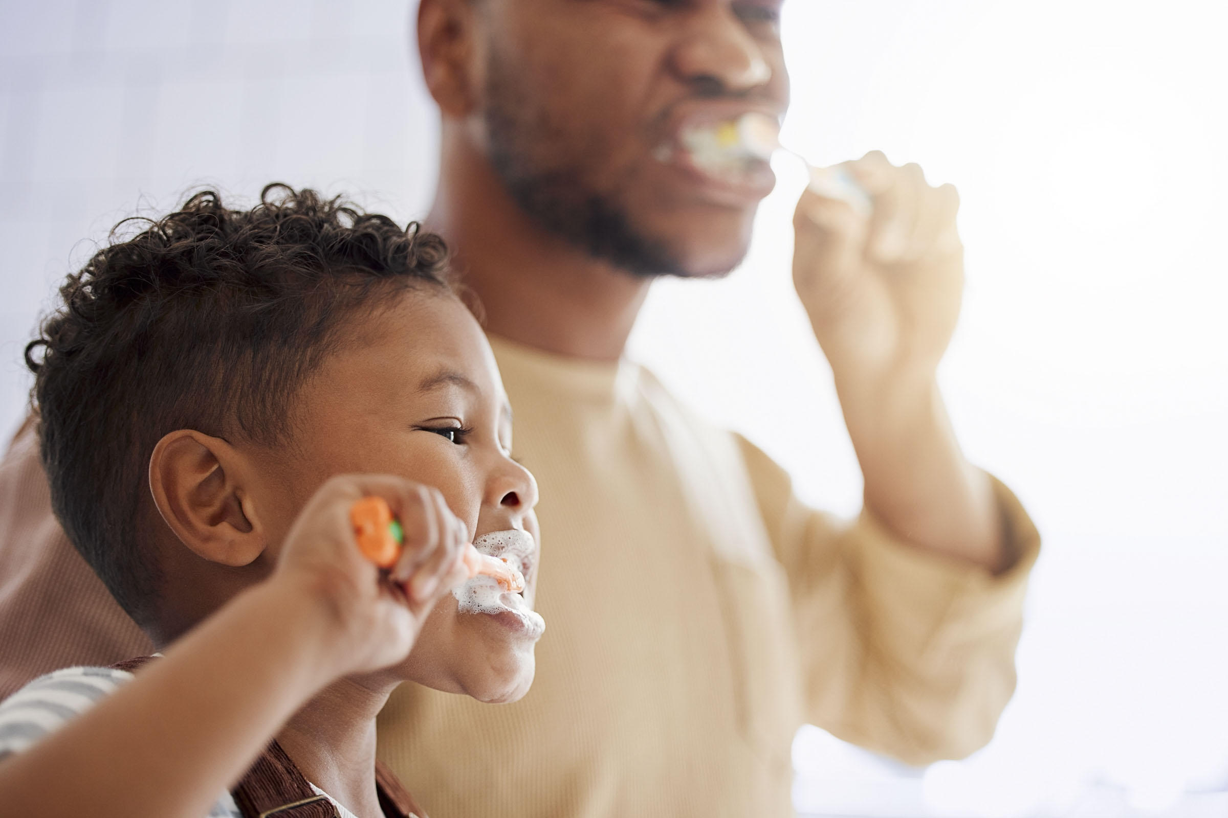 Sohn und Vater putzen Zähne